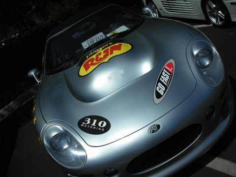 1998 Ford Crown Victoria - A silver sports car is adorned with racing decals, including 'Players R&N' and 'GO FAST!', with another vehicle visible in the background.