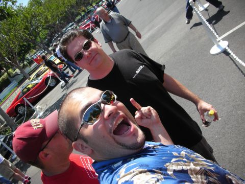 1998 Ford Crown Victoria - Three men pose for a photo at an outdoor event, with several cars visible in the background. One man is pointing towards the camera.