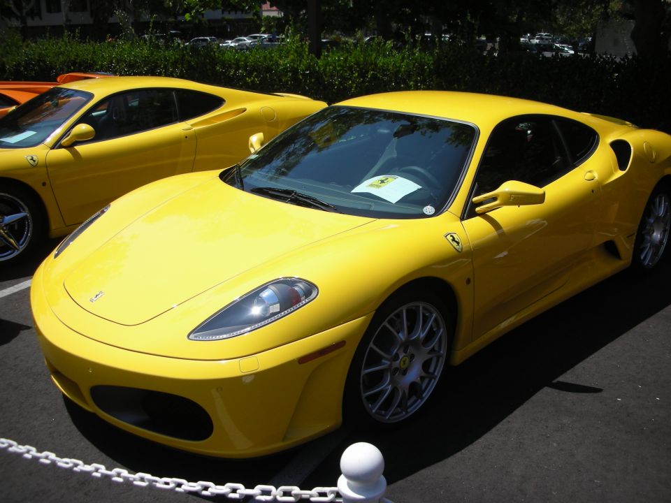 yellow Ferrari parked next to another yellow car