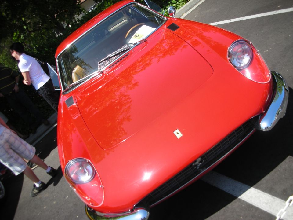 Red Ferrari front 3/4 view with chrome bumper and grille