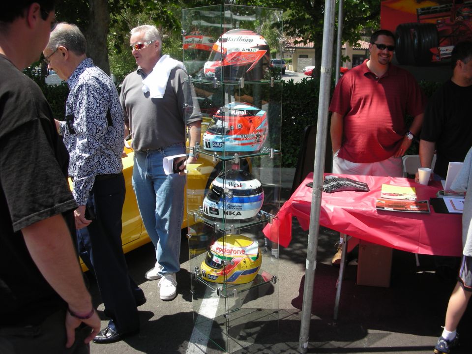 Display of racing helmets, including one with Vodafone branding