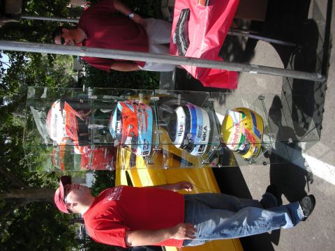 1998 Ford Crown Victoria - A display of racing helmets is set up outdoors, with a yellow car visible in the background.