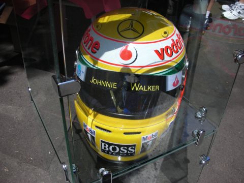 1998 Ford Crown Victoria - A yellow racing helmet with various sponsor logos is displayed in a glass case.
