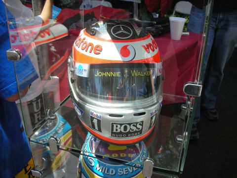 1998 Ford Crown Victoria - A racing helmet with sponsor logos is displayed in a glass case, with other helmets visible below.