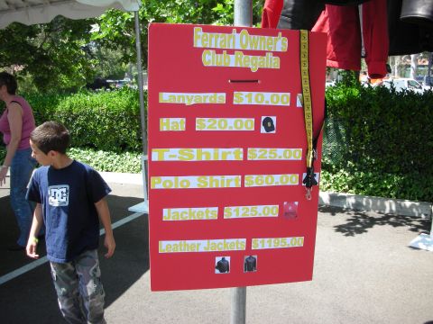 1998 Ford Crown Victoria - Photo of a Ferrari Owners Club regalia price board listing merchandise such as hats, shirts and jackets.
