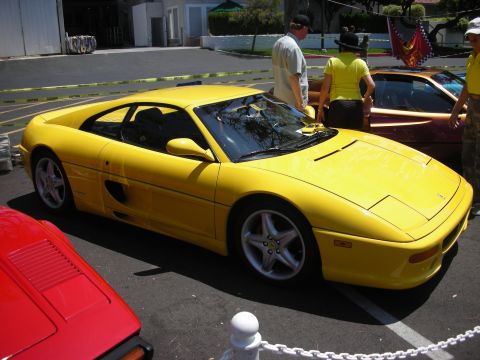 1998 Ford Crown Victoria - Yellow Ferrari F355 at a car show with other vehicles present.