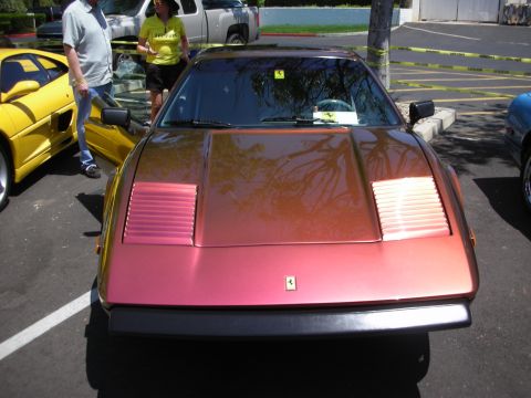 1998 Ford Crown Victoria - Front view of a metallic red/orange Ferrari 308 GTB/GTS with pop-up headlights.