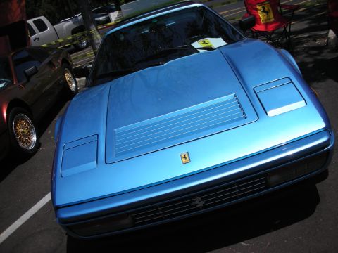 1998 Ford Crown Victoria - Front view of a blue Ferrari sports car, parked next to another vehicle.