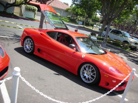1998 Ford Crown Victoria - A bright red Ferrari is parked with its rear glass lifted, revealing the interior.