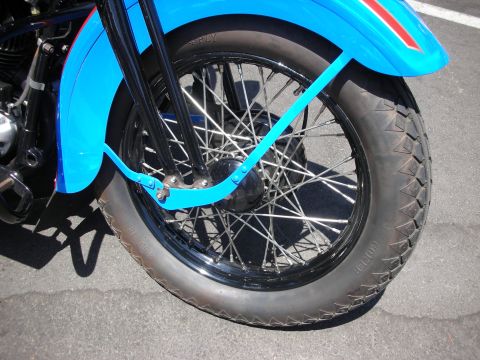 1998 Ford Crown Victoria - Close-up of a motorcycle's front wheel and blue fender.