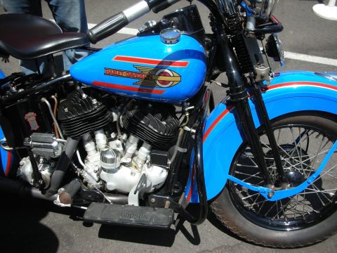 1998 Ford Crown Victoria - A close-up view of a vintage Harley-Davidson motorcycle, its distinctive blue fuel tank and engine components.