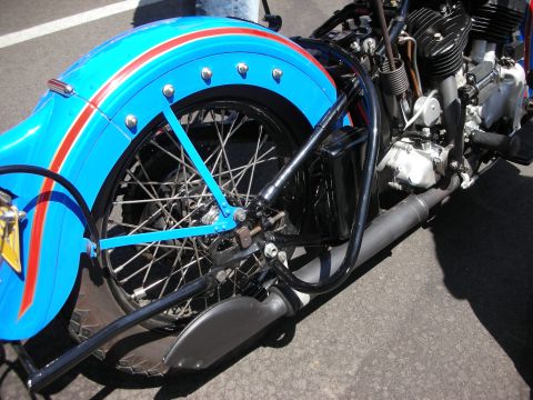 1998 Ford Crown Victoria - A close-up view of a custom motorcycle's rear fender and engine, painted blue with red racing stripes.