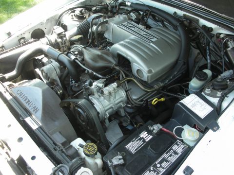 1998 Ford Crown Victoria - The engine bay features a 5.0 HO Ford engine cover and a prominent 'CAUTION FAN' shroud.