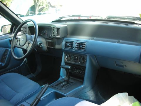 1998 Ford Crown Victoria - Interior view of a blue 1990s Ford Mustang dashboard and steering wheel.