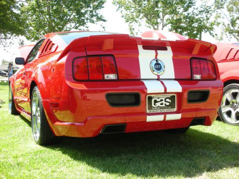 1998 Ford Crown Victoria - Rear view of a red Ford Mustang GT with racing stripes and a custom license plate frame.