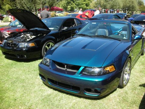 1998 Ford Crown Victoria - Three-quarter front view of a teal/blue color-shifting New Edge Mustang Cobra convertible with the top down, hood heat extractors, chrome f…