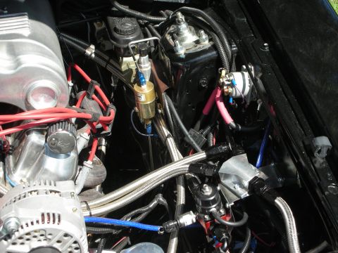 1998 Ford Crown Victoria - Close-up view of a modified engine bay, highlighting custom fuel system components and wiring.