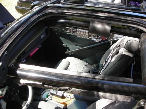 1998 Ford Crown Victoria - The interior of a modified car features racing seats, a roll cage, and a "5.0" badge, suggesting a performance-oriented build.