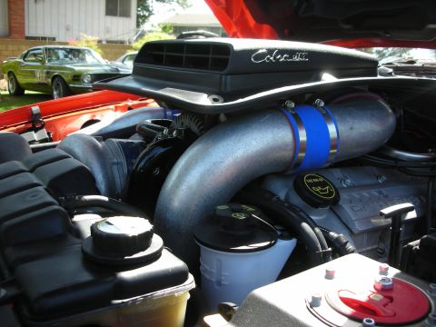 1998 Ford Crown Victoria - Close-up of a modified engine bay, with a classic Mustang visible in the background.