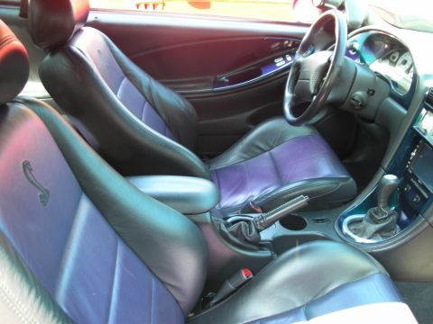 1998 Ford Crown Victoria - Car interior features black and purple two-tone seats and a manual transmission shifter.