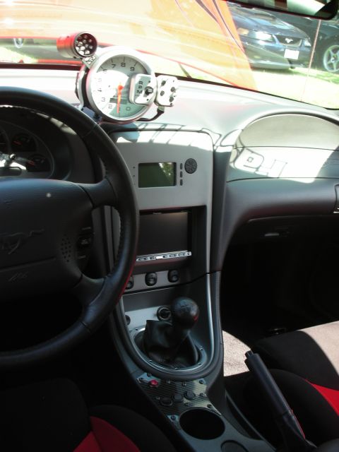 1998 Ford Crown Victoria - Car interior features a large tachometer and manual transmission; another vehicle is seen outside.