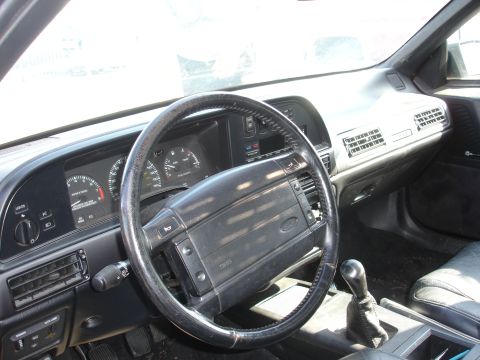 1991 Ford Taurus - The driver's side interior of a car shows the steering wheel, instrument cluster, and center console.