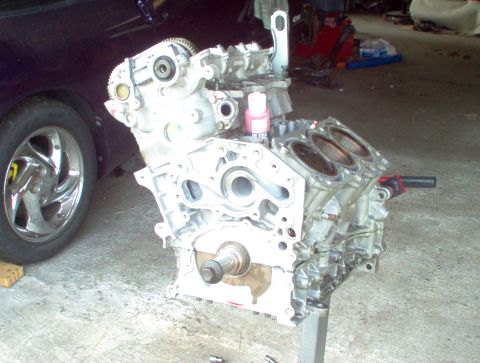 1996 Ford Probe - Engine block on a stand, with a car wheel visible to the left.