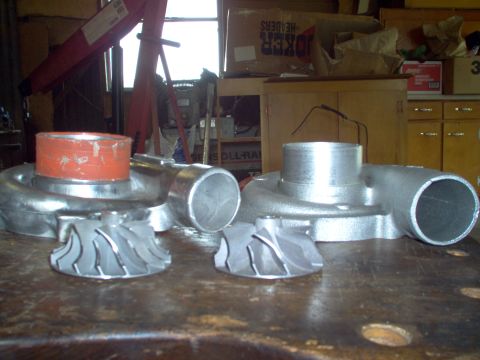 1996 Ford Probe - Turbocharger parts, including housings and turbine wheels, laid out on a workbench.