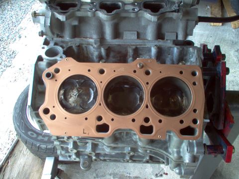 1996 Ford Probe - Engine block with a new gasket ready for installation, showing the cylinder heads and pistons.