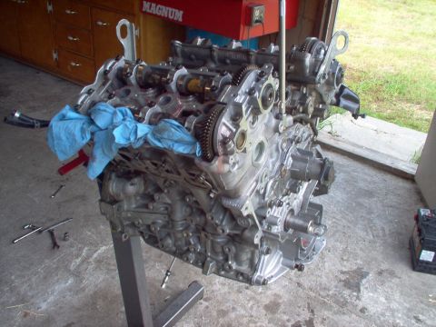 1996 Ford Probe - Engine assembly on a stand, showing internal components and gears, with tools scattered nearby.