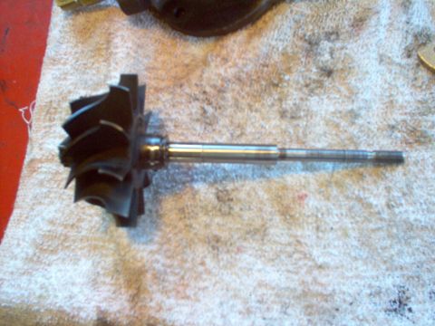 1996 Ford Probe - A turbocharger turbine wheel and shaft assembly is shown resting on a towel, likely before or after installation.