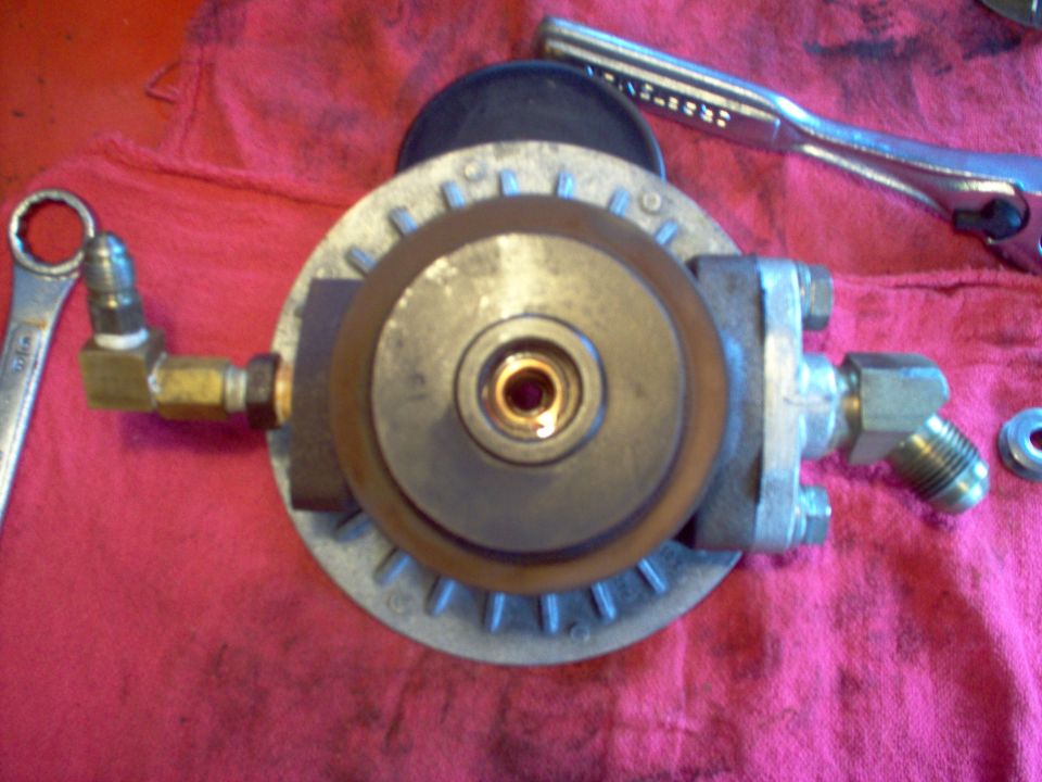 Fuel filter housing with brass fittings and a wrench on a red cloth