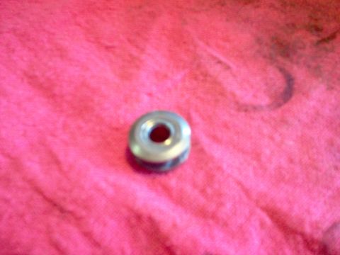 1996 Ford Probe - A single metal bearing is shown on a pink cloth background.