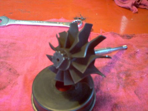 1996 Ford Probe - A turbocharger impeller and shaft are shown on a red surface with a wrench.