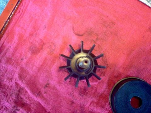 1996 Ford Probe - Impeller part shown on a red cloth with another circular part nearby.