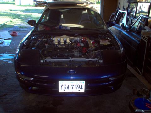 1996 Ford Probe - Front view of a blue coupe with its hood open, revealing the engine and various modifications. The license plate is visible.