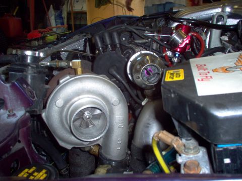 1996 Ford Probe - Close-up view of aftermarket turbocharger and engine modifications, including a blow-off valve and associated plumbing.