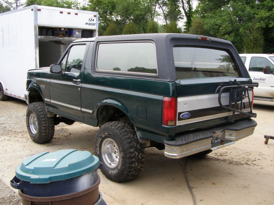 Green lifted 1993 Ford Bronco rear quarter view with spare tire carrier