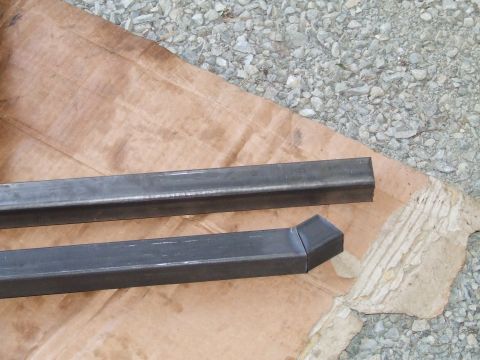 1979 Ford Bronco - Two pieces of metal tubing are shown, one with a mitered end, on brown paper.