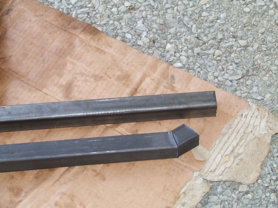 Two pieces of square metal tubing, one with an angled cut end