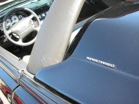 1998 Ford Crown Victoria - Interior view of a black convertible, a steering wheel with a Mustang emblem and a prominent "SUPERCHARGED" badge.