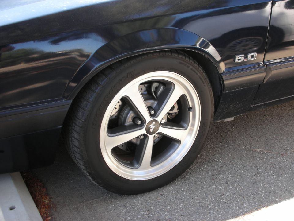Black car fender with 5.0 badge and five-spoke wheel