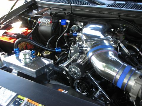 1998 Ford Crown Victoria - Close-up of a modified engine bay a polished supercharger and various aftermarket components.