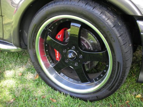 1998 Ford Crown Victoria - Close-up of a custom car wheel with red brake calipers and Pirelli Scorpion Zero tires.