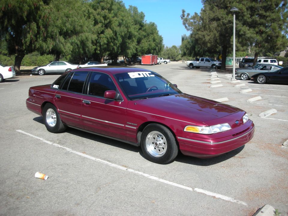 maroon sedan parked in a lot, has a sticker on the windshield that says "OTC"