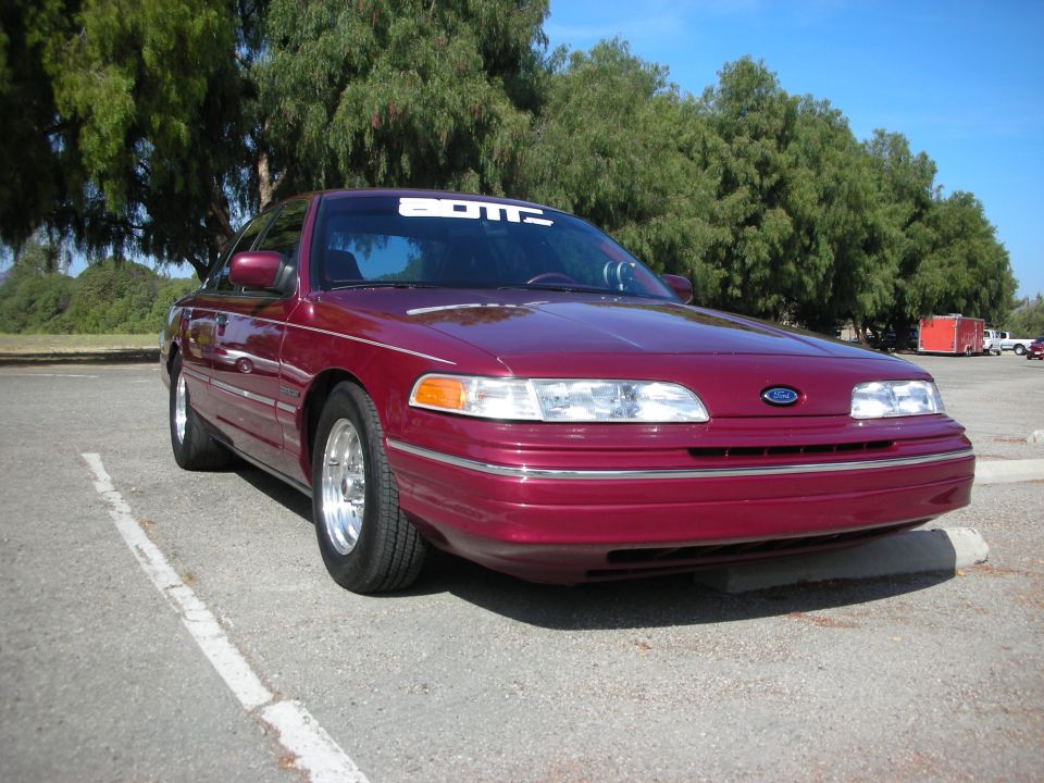 Maroon 1998 Ford Crown Victoria, 3q-front view, with a white banner on windshield