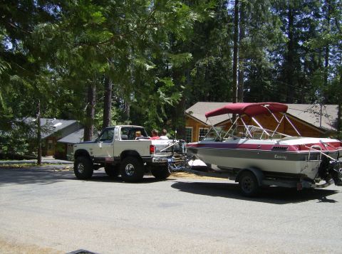 1986 Ford Bronco - A white 1986 Ford Bronco is seen towing a boat near a cabin.