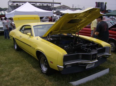1970 Ford Ranchero - A yellow 1970 Dodge Charger is displayed with its hood open, revealing the engine bay.