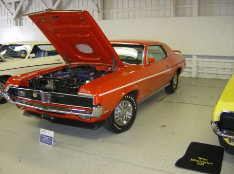 1970 Ford Ranchero - This orange 1969 Mercury Cougar is displayed with its hood open, revealing the engine and interior details.