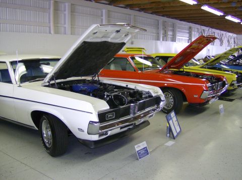 1970 Ford Ranchero - Multiple classic cars, including a white 1969 Mercury Cougar, are displayed with their hoods open.